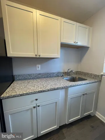 a kitchen with granite countertop a sink and cabinets
