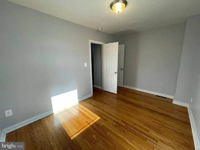 a view of an empty room and wooden floor