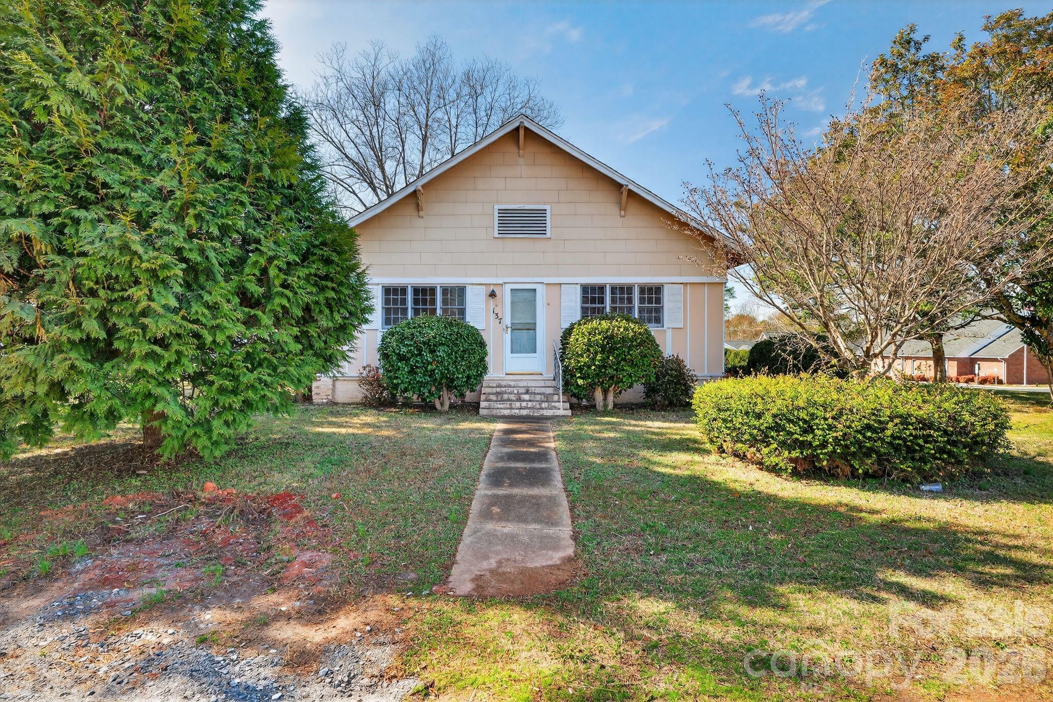 137 Duke Street Granite Falls, NC 28630 - Photo 3 of 16 a view of a yard in front of a house with plants and large tree