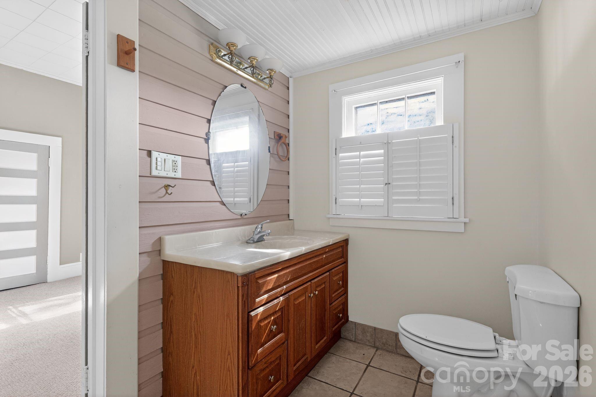 137 Duke Street Granite Falls, NC 28630 - Photo 10 of 16 a bathroom with a granite countertop toilet a sink and a mirror