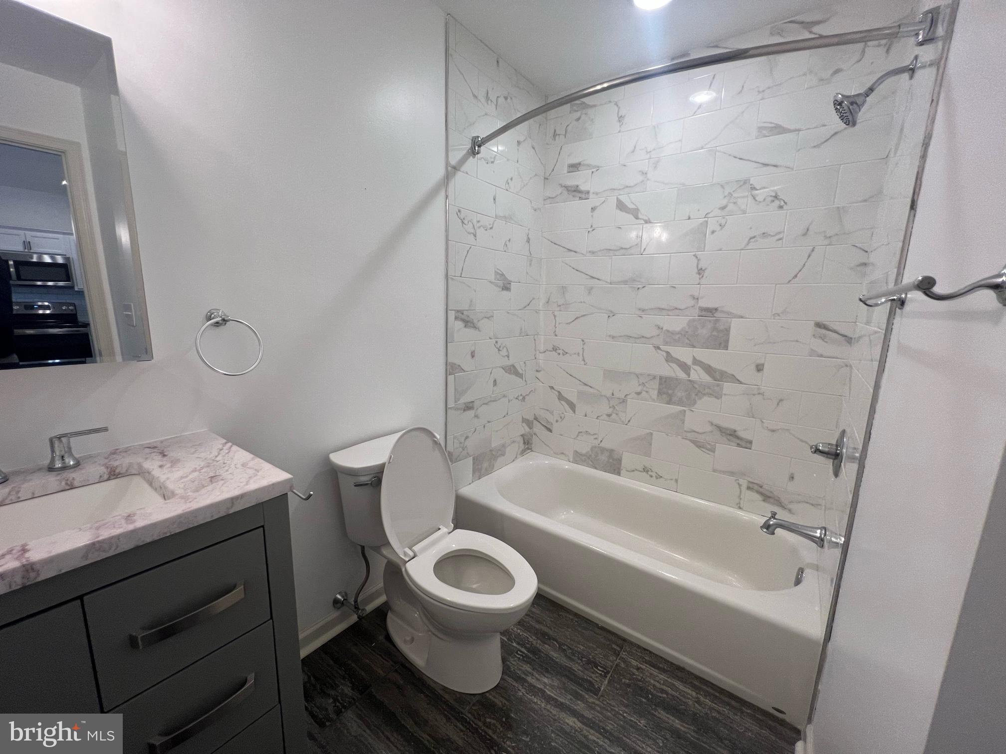 5312 Ridge Avenue, Unit 407 Philadelphia, PA 19128 - Photo 3 of 7 a bathroom with a bathtub toilet sink and a shower