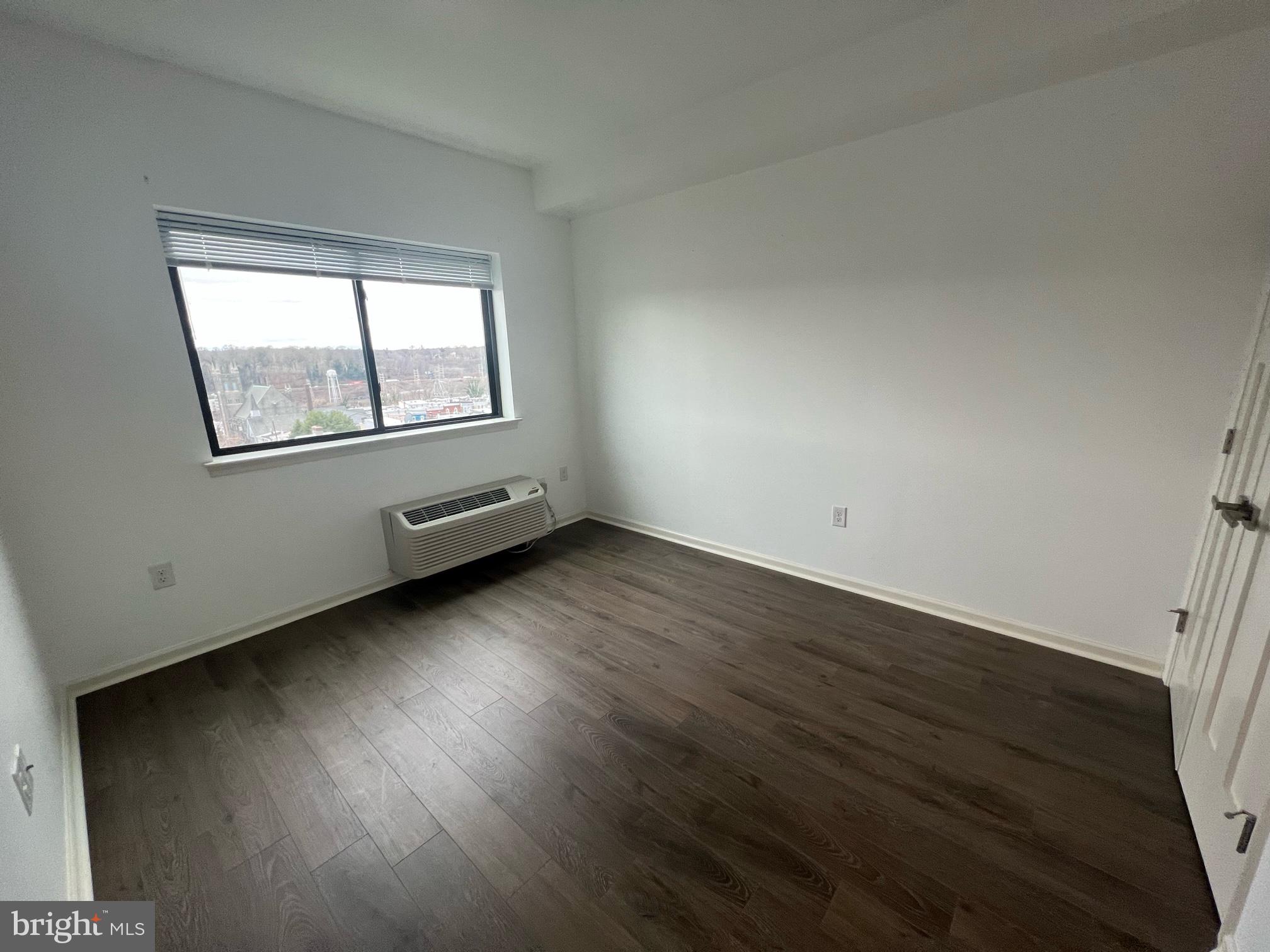 5312 Ridge Avenue, Unit 407 Philadelphia, PA 19128 - Photo 6 of 7 an empty room with wooden floor and windows