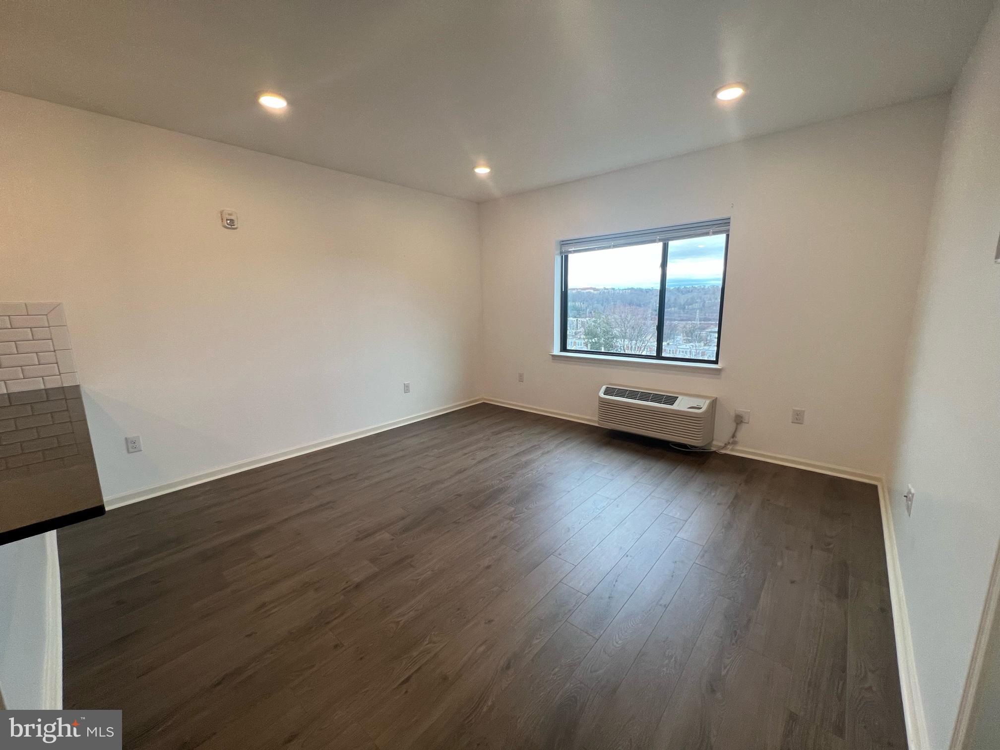 5312 Ridge Avenue, Unit 407 Philadelphia, PA 19128 - Photo 7 of 7 an empty room with wooden floor and windows