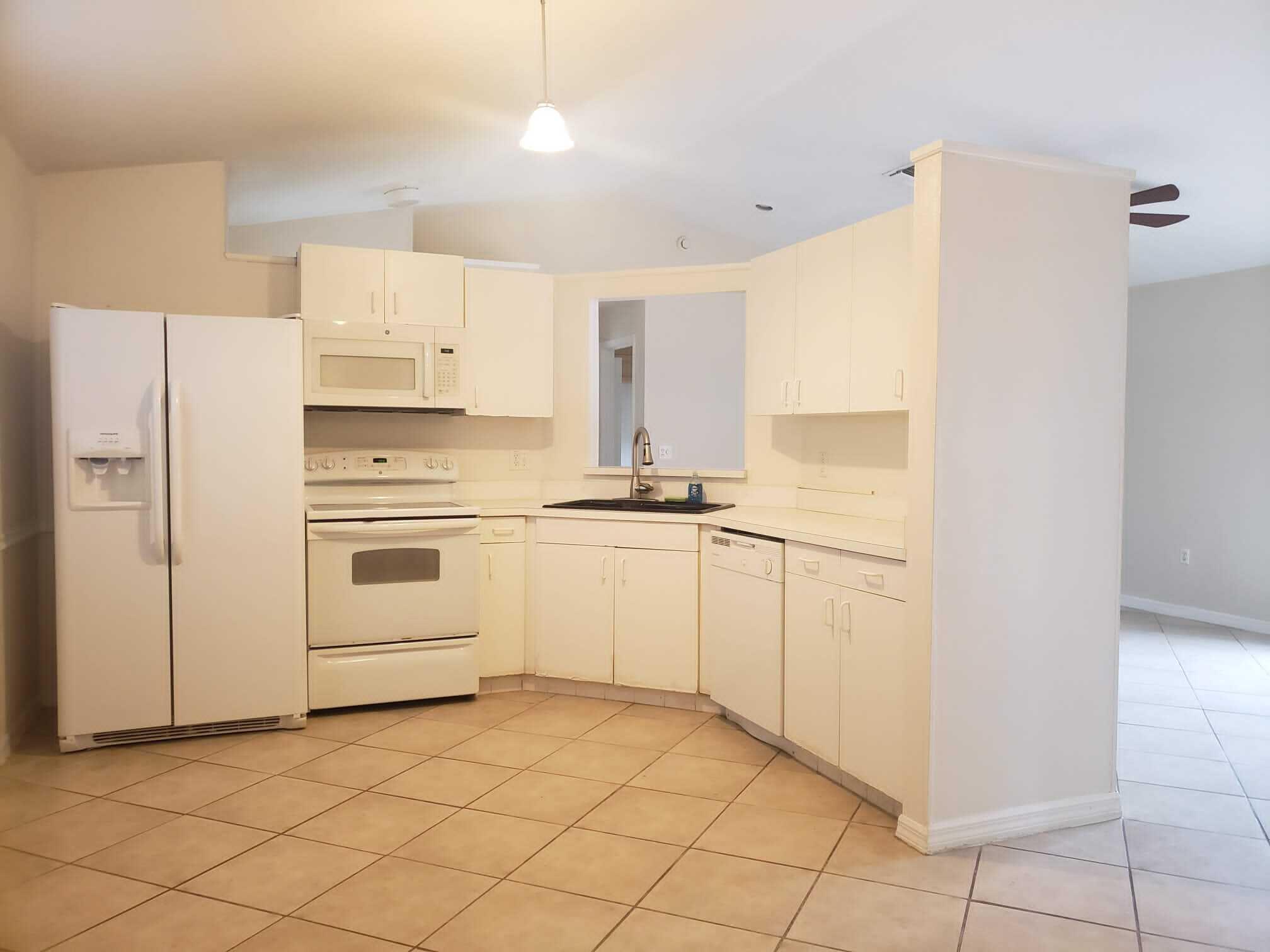 3409 12th Street Southwest Vero Beach, FL 32968 - Photo 25 of 26 a kitchen with white cabinets and white appliances