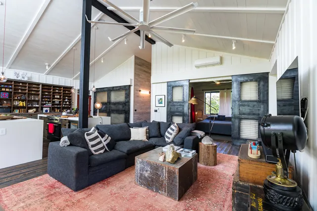 a living room with furniture a flat screen tv and a floor to ceiling window