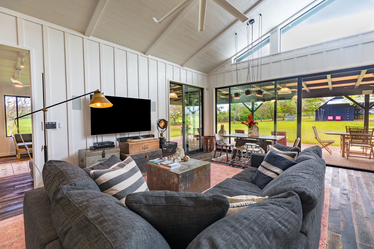 2671 Kauapea Road Kilauea, HI 96754 - Photo 16 of 30 a living room with furniture a flat screen tv and a floor to ceiling window