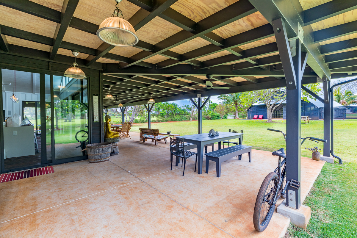 2671 Kauapea Road Kilauea, HI 96754 - Photo 22 of 30 a view of a patio with table and chairs potted plants with floor to ceiling window