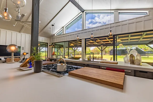 a living room with furniture a flat screen tv and a large window