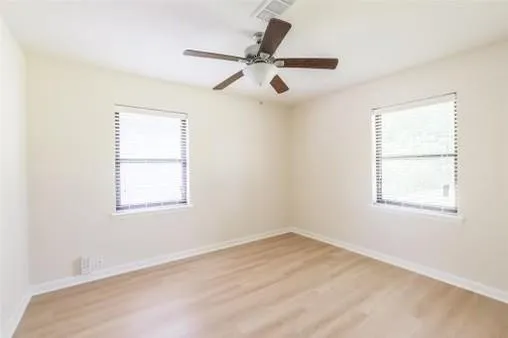 an empty room with a window and a fan
