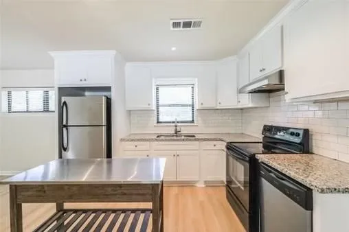 a kitchen with stainless steel appliances granite countertop a sink stove and refrigerator