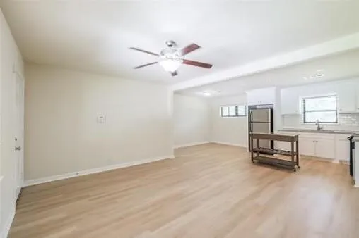a view of a room with gym equipment and a ceiling fan