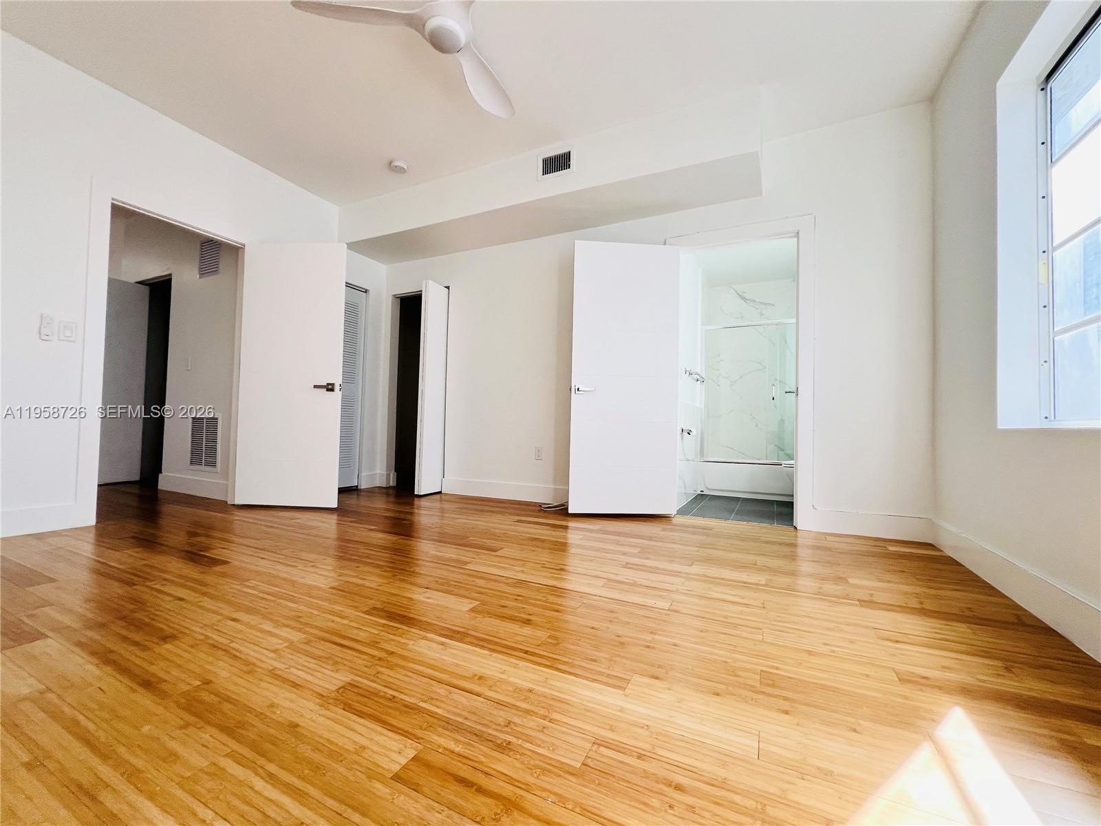 960 Bay Drive, Unit 902 Miami Beach, FL 33141 - Photo 13 of 25 a view of an empty room with window and wooden floor
