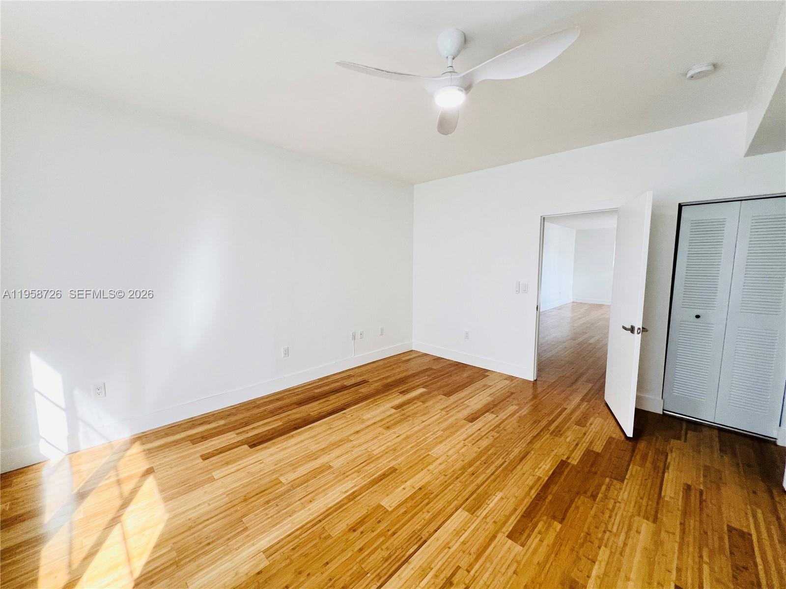 960 Bay Drive, Unit 902 Miami Beach, FL 33141 - Photo 15 of 25 a bedroom with a bed and a wooden floor