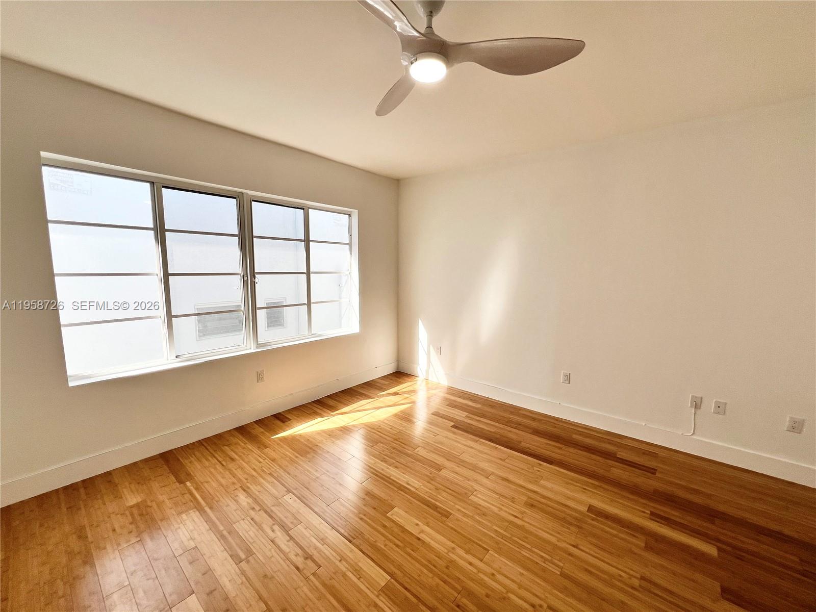 960 Bay Drive, Unit 902 Miami Beach, FL 33141 - Photo 16 of 25 wooden floor in an empty room with a window