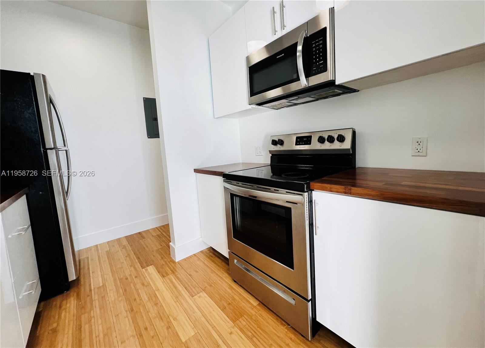 960 Bay Drive, Unit 902 Miami Beach, FL 33141 - Photo 7 of 25 a kitchen with stainless steel appliances a stove microwave and sink