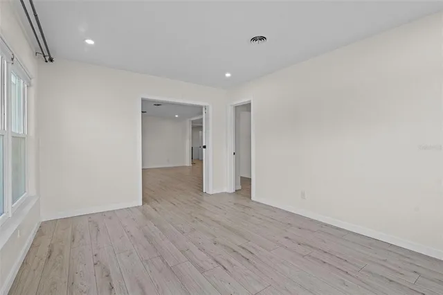 a view of an empty room with wooden floor
