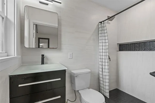 a bathroom with a toilet sink and mirror