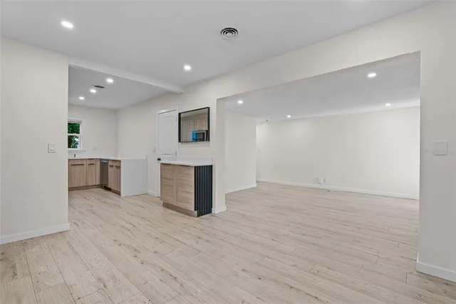 a view of empty room with wooden floor and fireplace