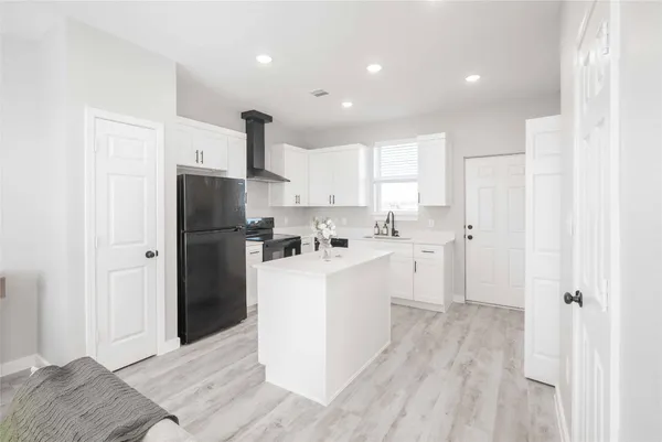 a kitchen with a refrigerator and a sink