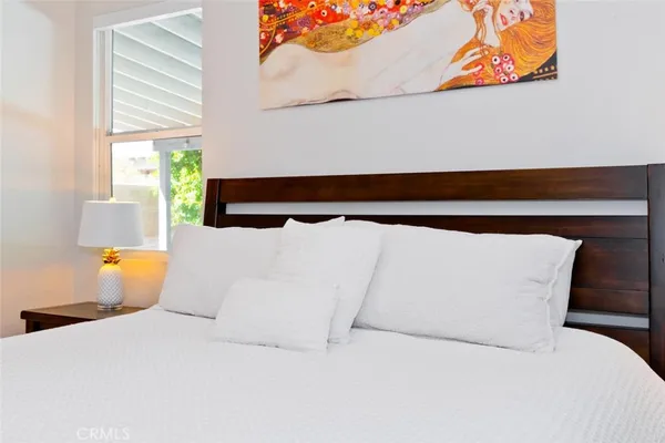 a bedroom with a bed and a potted plant