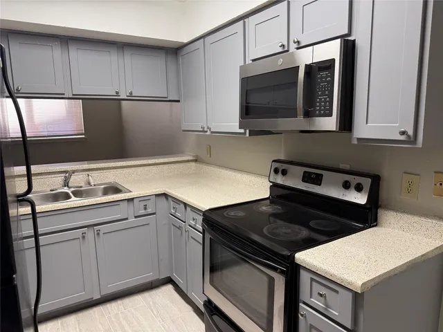 a kitchen with a sink stove and microwave