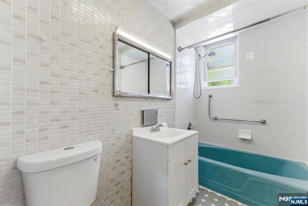 773 Kingsland Avenue Ridgefield, NJ 07657 - Photo 11 of 13 a bathroom with a toilet sink and mirror
