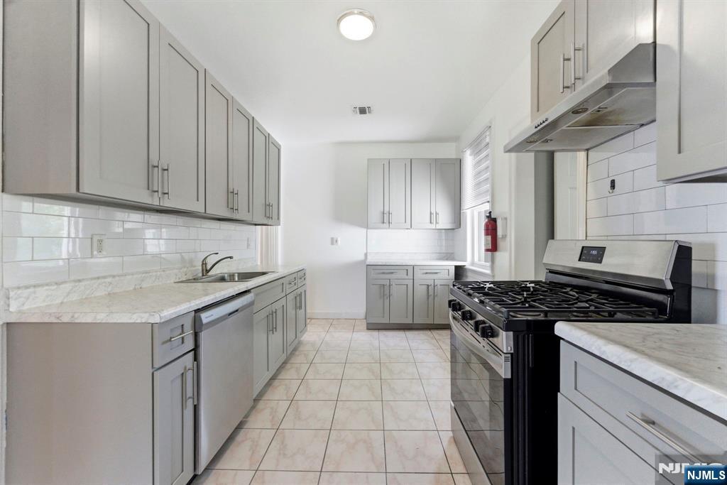 773 Kingsland Avenue Ridgefield, NJ 07657 - Photo 3 of 13 a kitchen with stainless steel appliances granite countertop a sink stove and cabinets