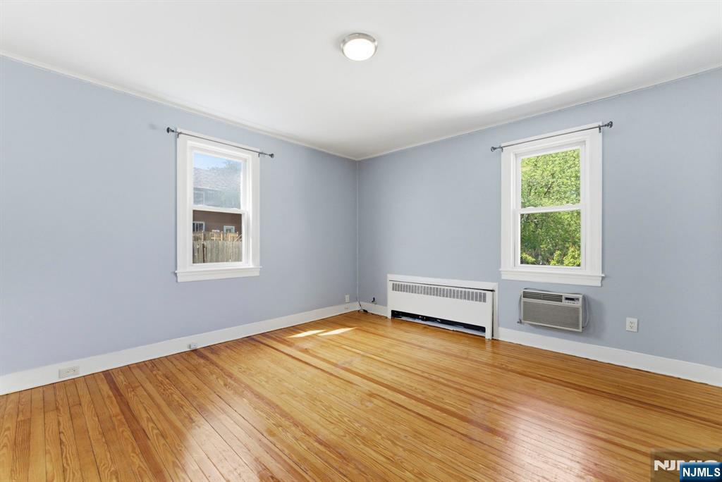 773 Kingsland Avenue Ridgefield, NJ 07657 - Photo 10 of 13 an empty room with wooden floor and windows