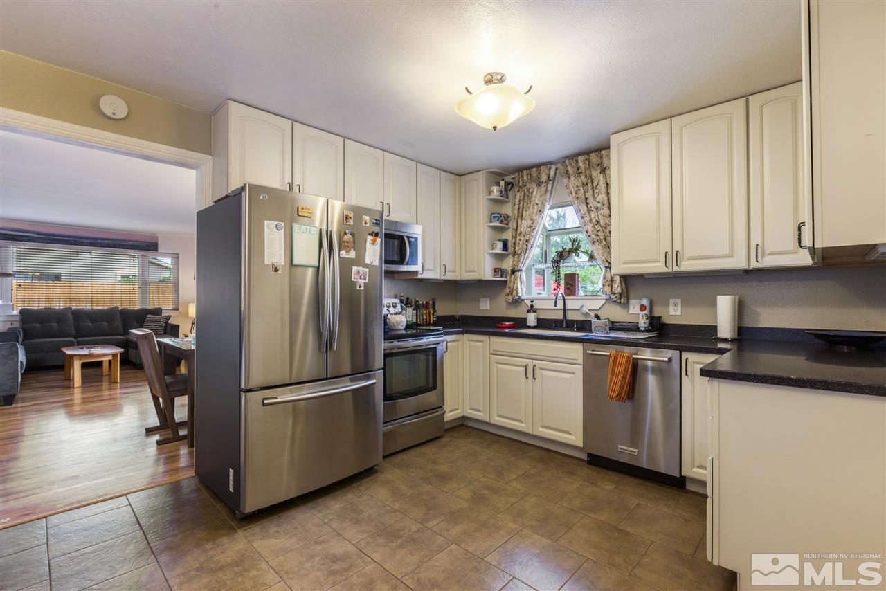 1545 Elizabeth Street Reno, NV 89509 - Photo 8 of 21 a kitchen with granite countertop a refrigerator a sink a stove and cabinets