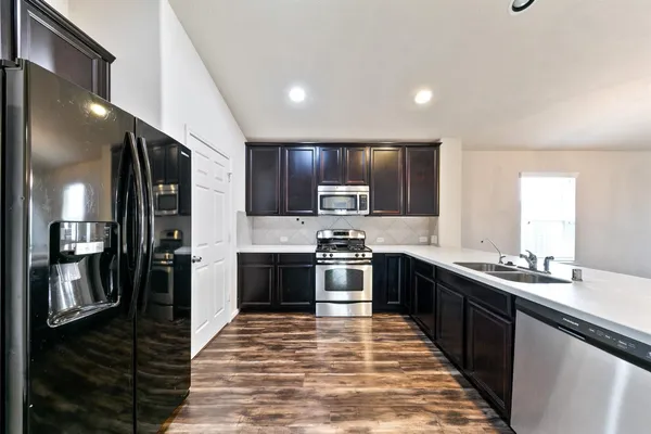 a large kitchen with stainless steel appliances granite countertop a stove a sink dishwasher and a refrigerator
