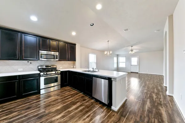 a large kitchen with stainless steel appliances granite countertop a stove and cabinets