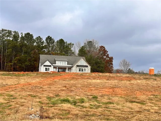 a front view of a house with a yard and palm trees