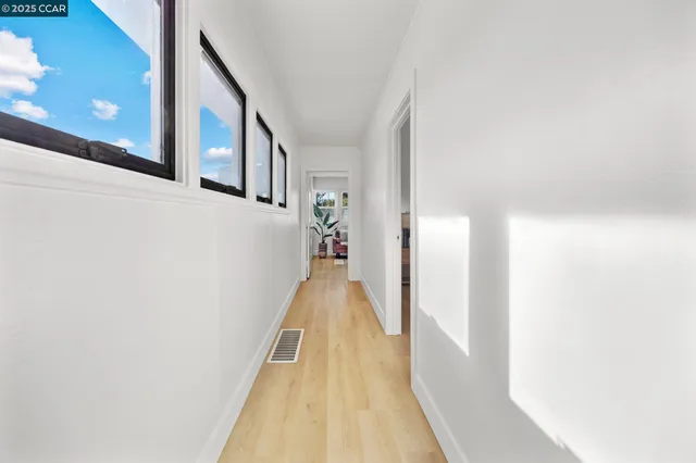 a view of a hallway with wooden floor and staircase
