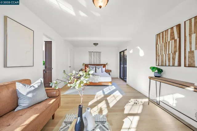 a living room with furniture flowerpot and wooden floor