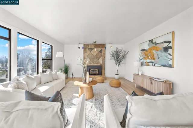 a living room with furniture a large window and a fireplace