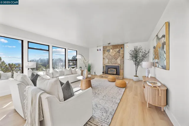 a living room with furniture large window and fireplace