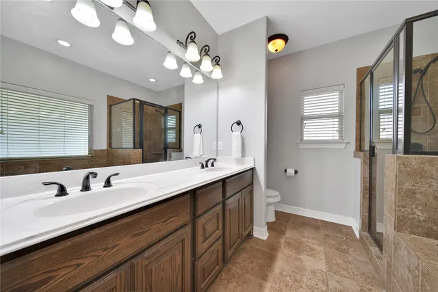 a bathroom with a granite countertop shower a sink and a mirror