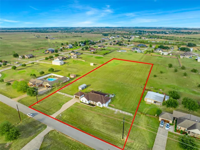 a very nice looking house with a big yard and potted plants