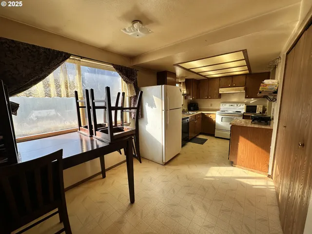 a view of kitchen with furniture and a refrigerator