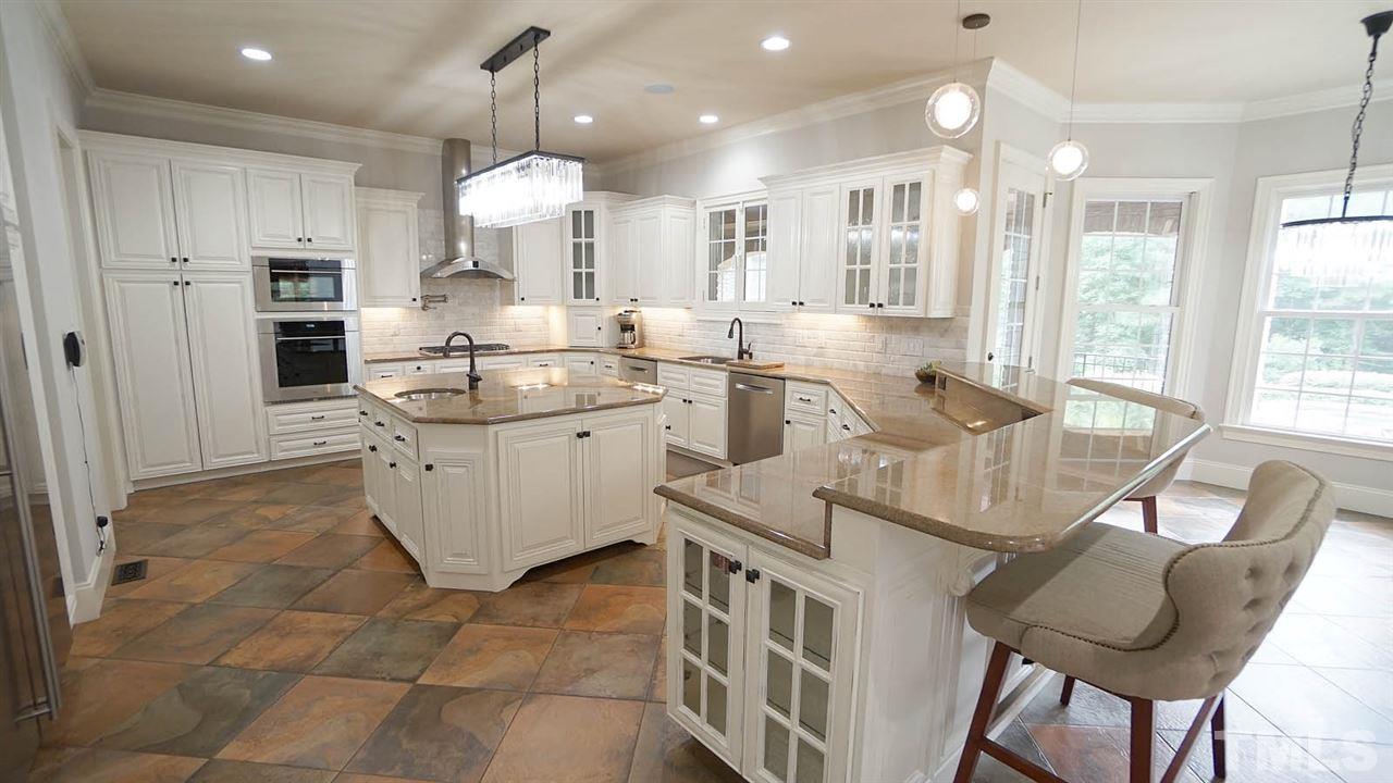 1608 Sharnbrook Court Raleigh, NC 27614 - Photo 12 of 30 White cabinets, subway tile back splash, and top of line updated appliances. Open view to family room or expansive views of outdoor oasis