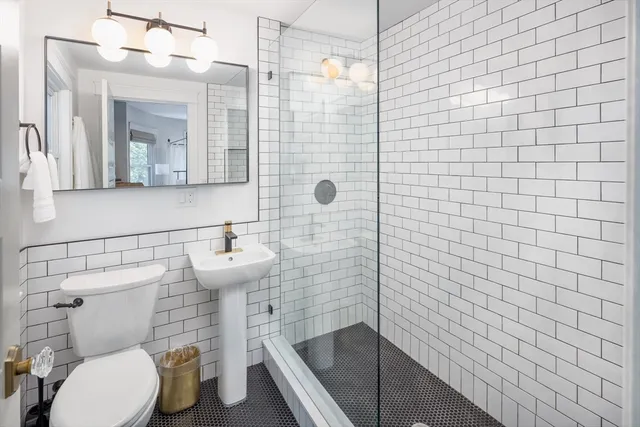 a bathroom with a toilet a sink and shower