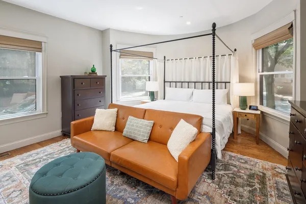 a living room with a couch and a dresser next to a window