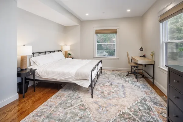 a bedroom with a bed tv and a window