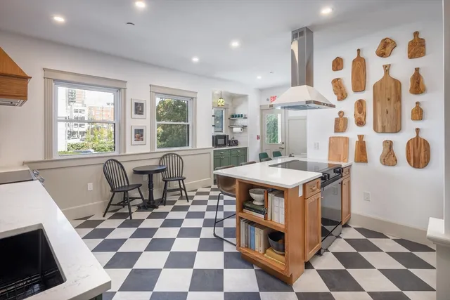 a kitchen with a stove a sink a counter top space and windows