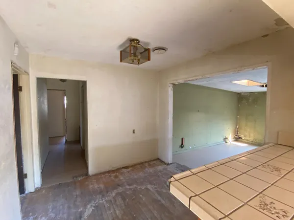 an empty room with windows and fireplace