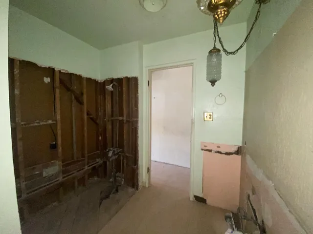 a view of a hallway with a chandelier fan