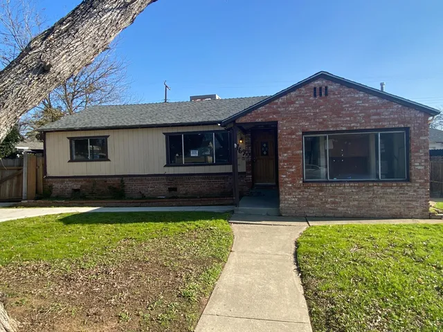 a view of house with yard and outdoor seating