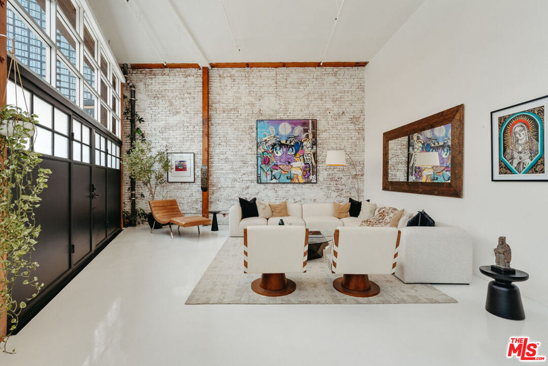 a living room with furniture and a painting on the wall