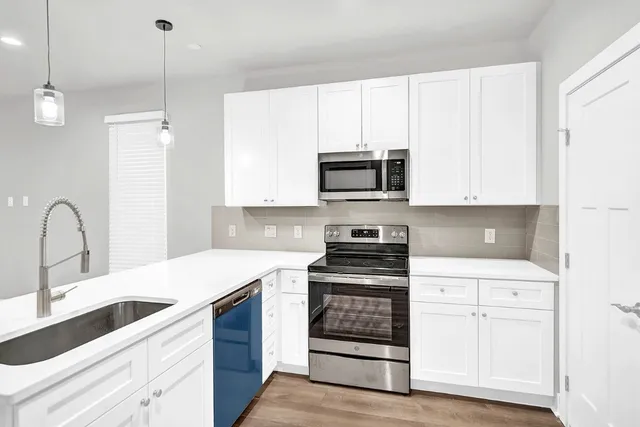 a kitchen with appliances a sink and cabinets