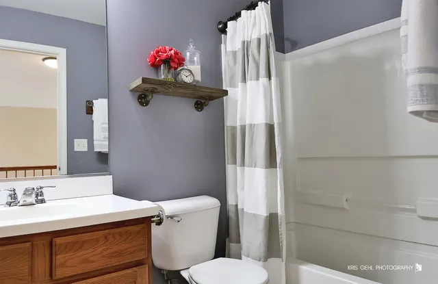 a bathroom with a sink vanity mirror and toilet